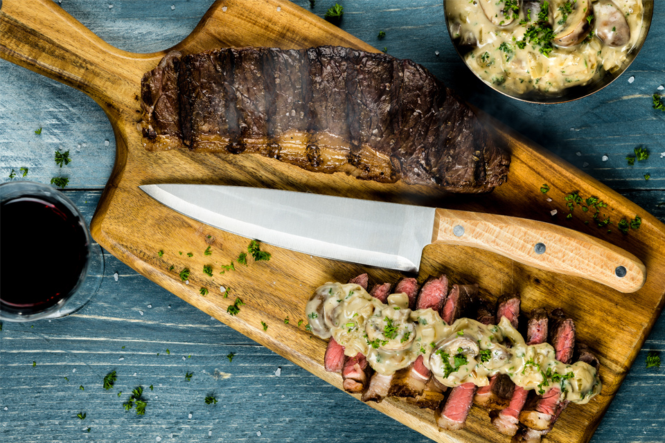 Gegrilde Entrecote op snijplank met koksmes