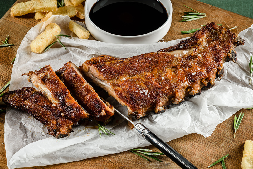 Food Fotografie van Gegrilde spareribs op een snijplank met frietjes